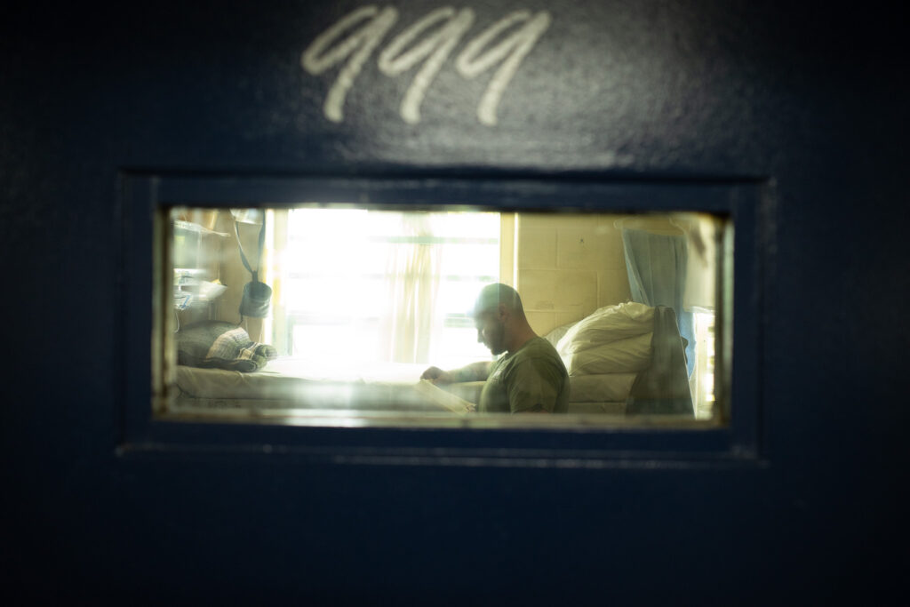 A resident reading in his cell.